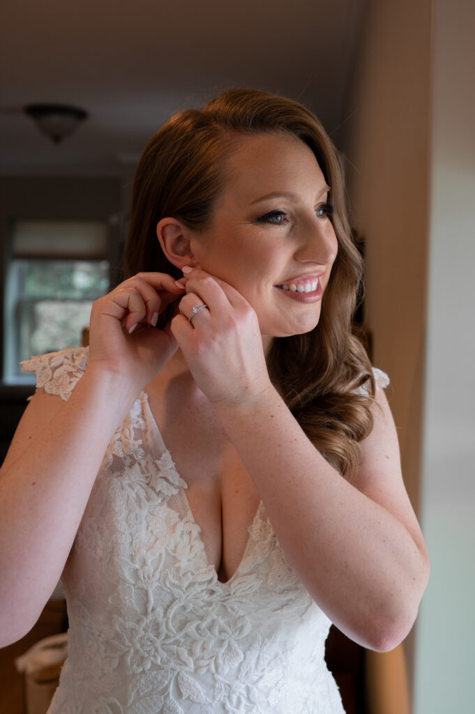 The bride fixing her earrings while getting ready.