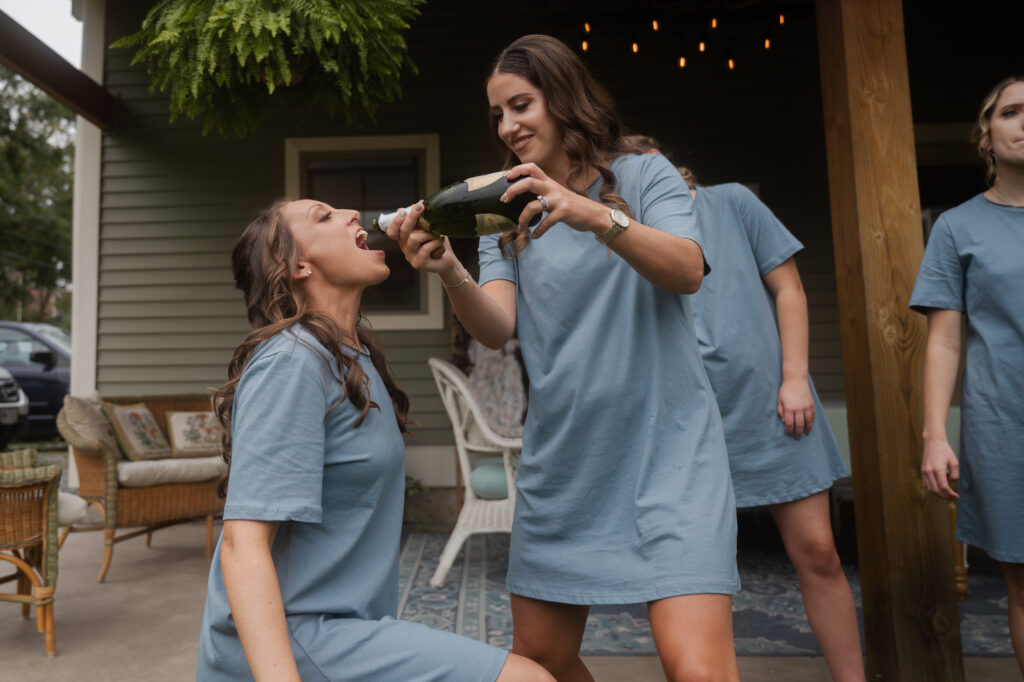 Bridesmaids sharing champagne out of the bottle.