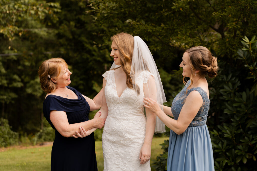 Leah's mom and sister helping adjust her veil.