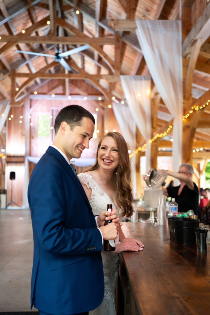 The newlyweds ordering a drink from the bar at Juniper Springs Wedding Barn.