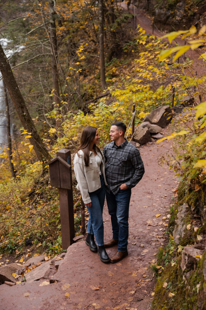 Taking a break on a landing at Kaaterskill Falls during their engagement session in the Catskill Mountains.