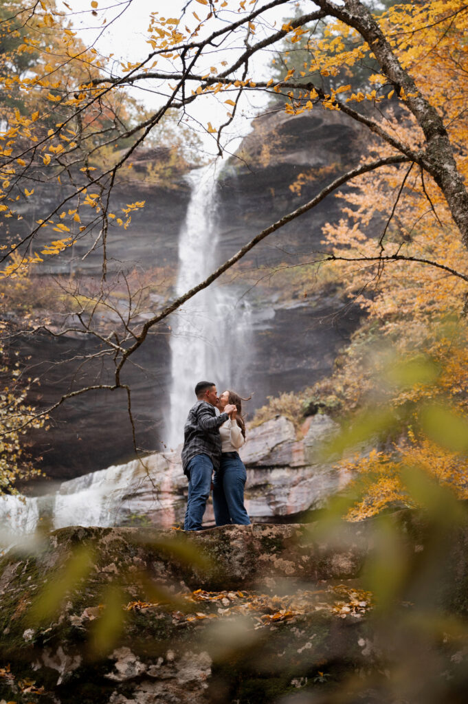 Aubrie and Dolan sharing a kiss just below Kaaterskill Falls during their engagement session in the Catskill Mountains.