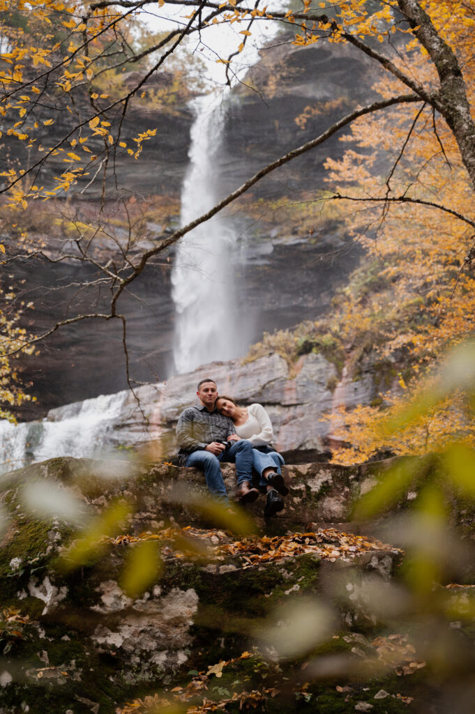 Aubrie and Dolan snuggling up at Kaaterskill Falls during their engagement session in the Catskill Mountains.