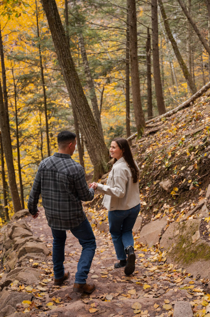 Catskills Wedding Photographer - Aubrie helping Dolan down the trail towards Kaaterskill Falls during their engagement session in the Catskill Mountains.