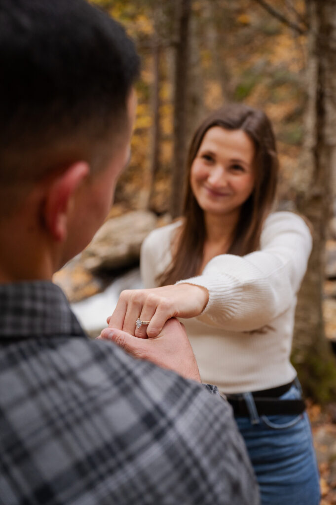 Dolan admiring Aubrie's ring at Kaaterskill Falls during their engagement session in the Catskill Mountains.