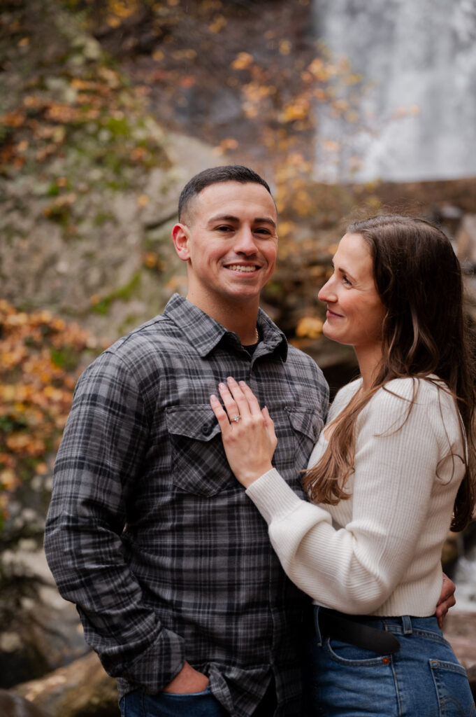 Aubrie and Dolan sharing an embrace just below Kaaterskill Falls during their engagement session in the Catskill Mountains.