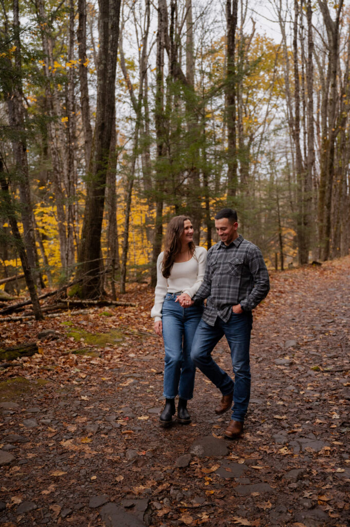 Aubrie and Dolan walking a trail near Kaaterskill Falls during their engagement session in the Catskill Mountains.