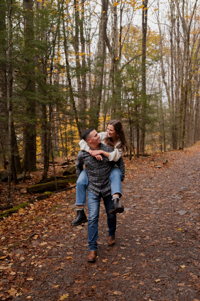 Dolan giving Aubrie a piggyback ride near Kaaterskill Falls during their engagement session in the Catskill Mountains.