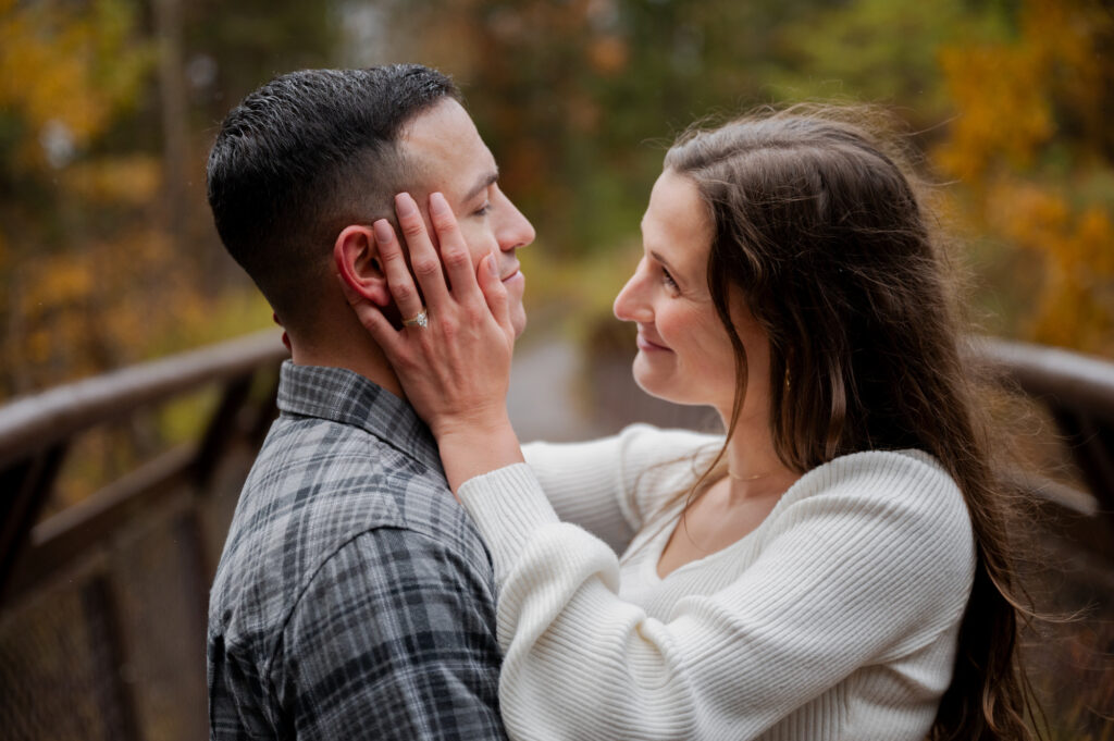 Catskills Wedding Photographer - Aubrie and Dolan sharing an embrace on the bridge at Kaaterskill Falls during their engagement session in the Catskill Mountains.