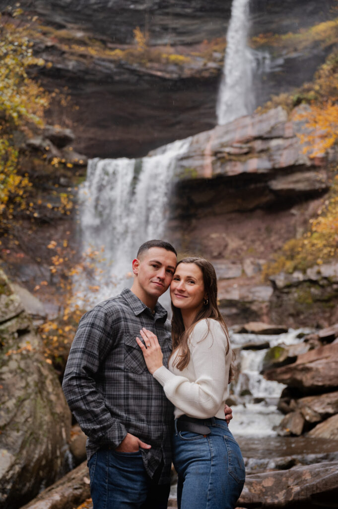 Aubrie and Dolan sharing an embrace just below Kaaterskill Falls during their engagement session in the Catskill Mountains.