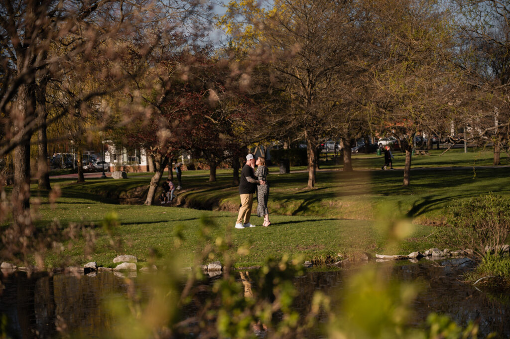 Sharing a kiss at Congress Park in Saratoga Springs, NY during their engagement photos with Austin Ryan Photo.