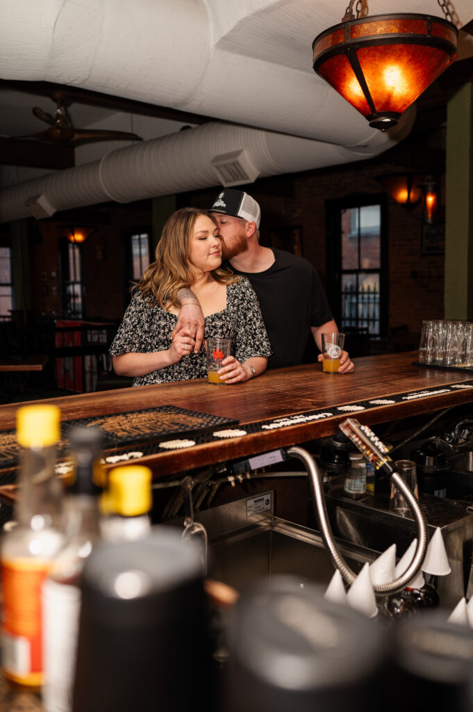 A couple with the bar to themselves at Harvey's Pub in downtown Saratoga Springs during their engagement photos with Austin Ryan Photo.