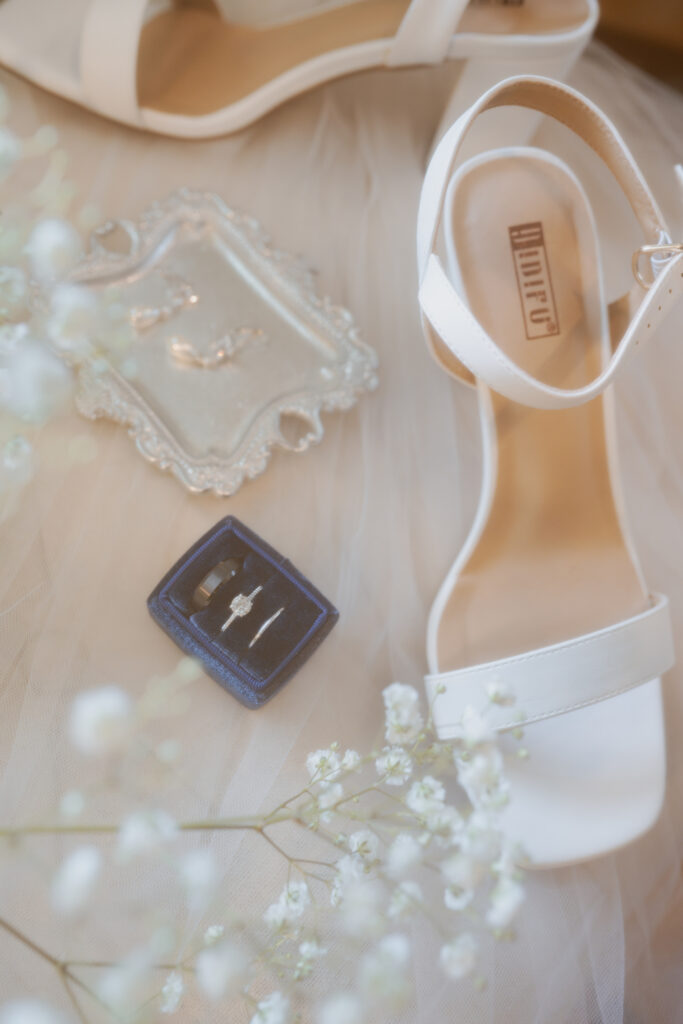 A dreamy flatlay of their rings and the brides shoes and earrings.