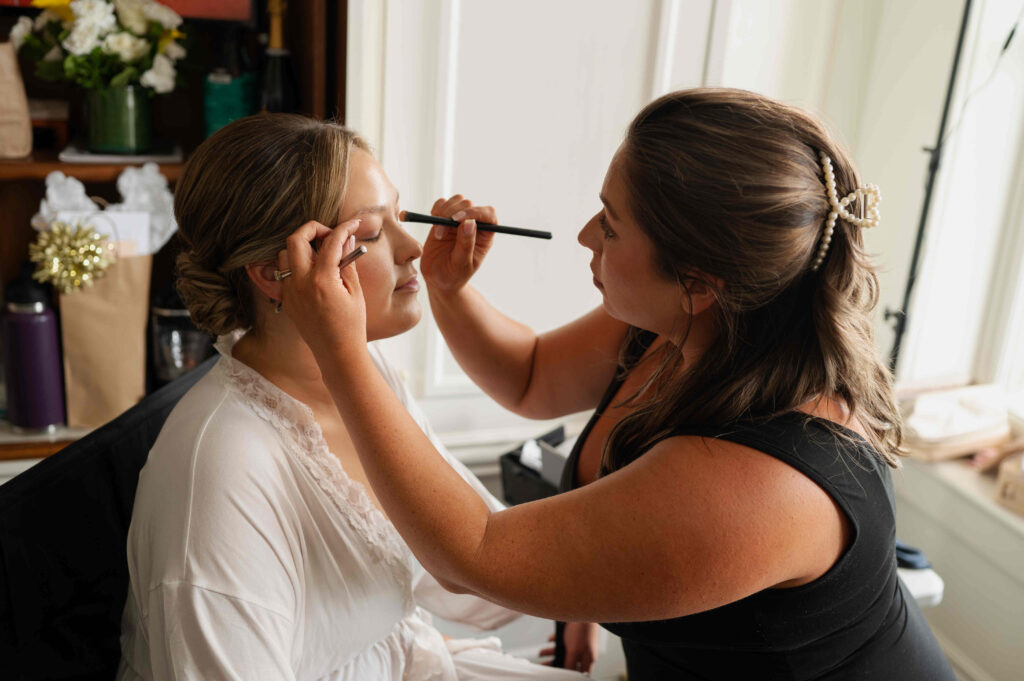 The bride getting her makeup done before the wedding at The Adelphi Hotel in Saratoga Springs, New York.