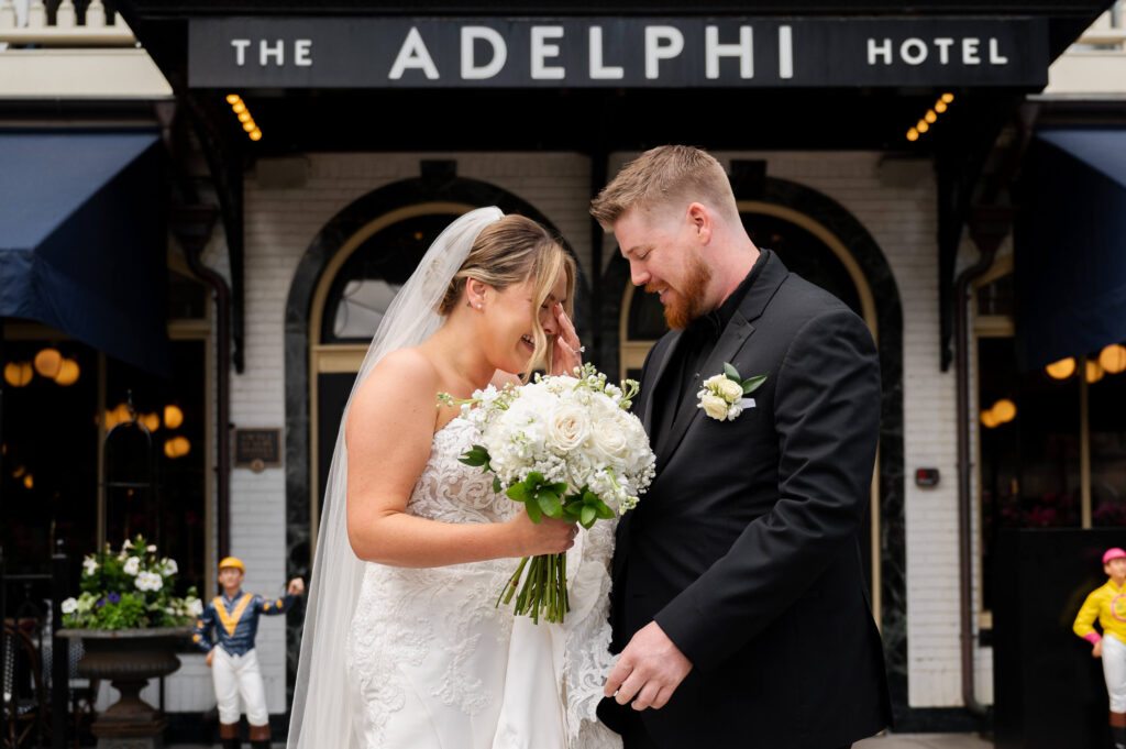 The bride's reaction to being surprised with charms of loved ones on her bridal bouquet outside of The Adelphi Hotel.