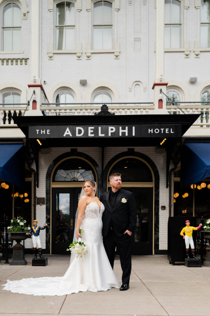 The bride and groom posing for a portrait outside of The Adelphi Hotel in Saratoga Springs, New York.