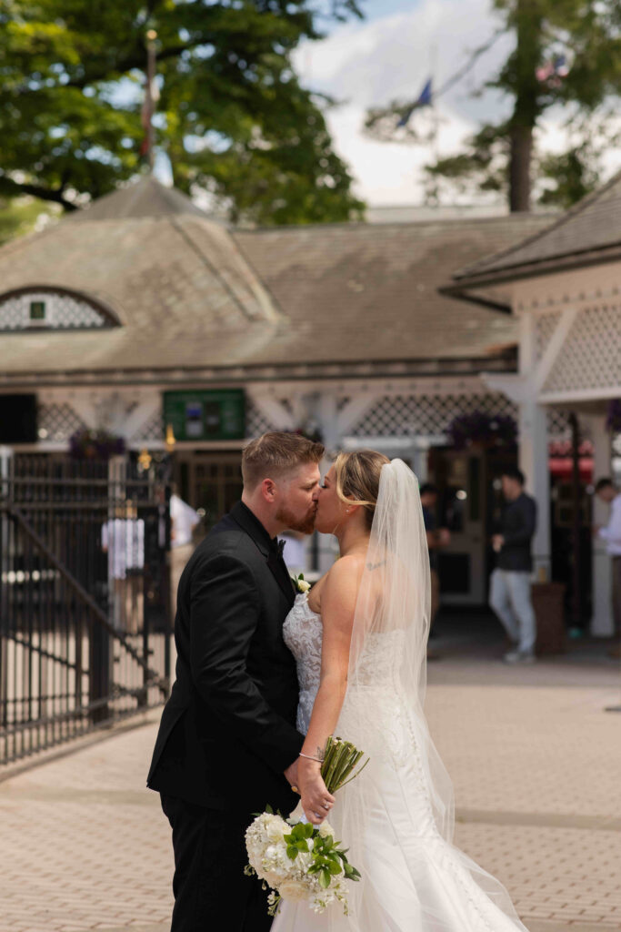 The bride and groom share a kiss at the Saratoga Race Course just hours before the Belmont Stakes.