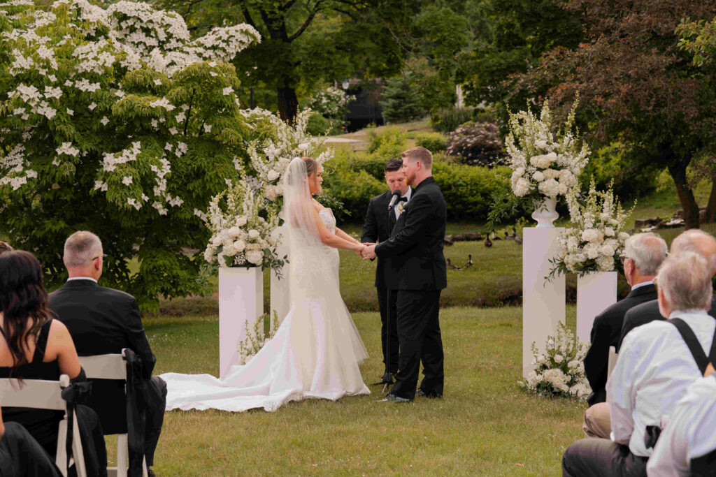 The bride and groom holding hands during their romantic wedding ceremony in Congress Park.