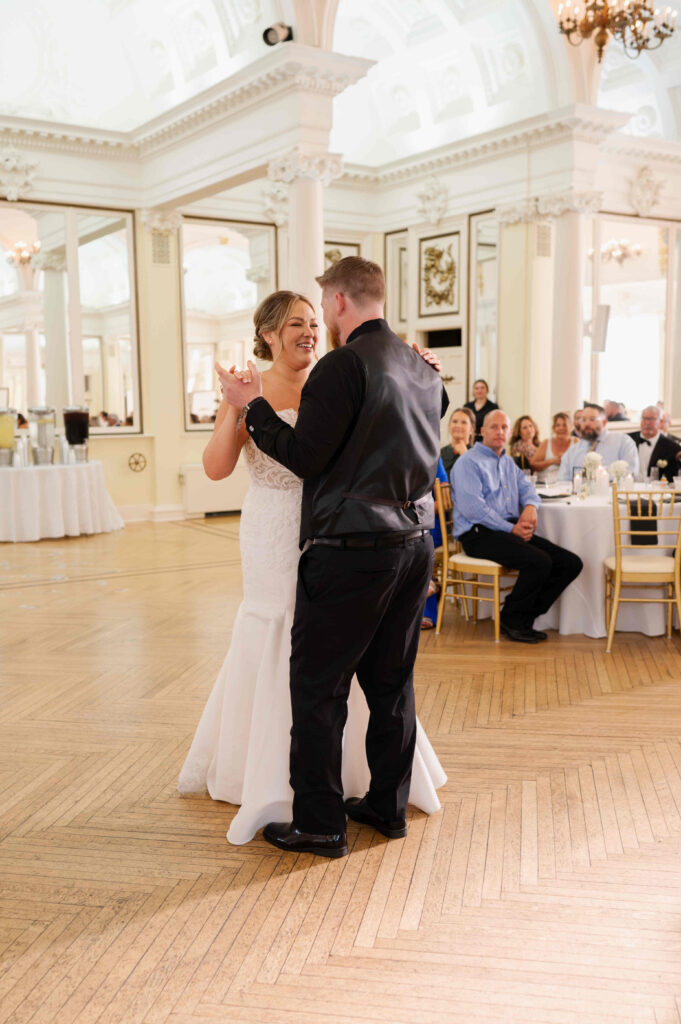 The bride and groom sharing their first dance in the ballroom of the Canfield Casino during a wedding in Saratoga Springs, New York.