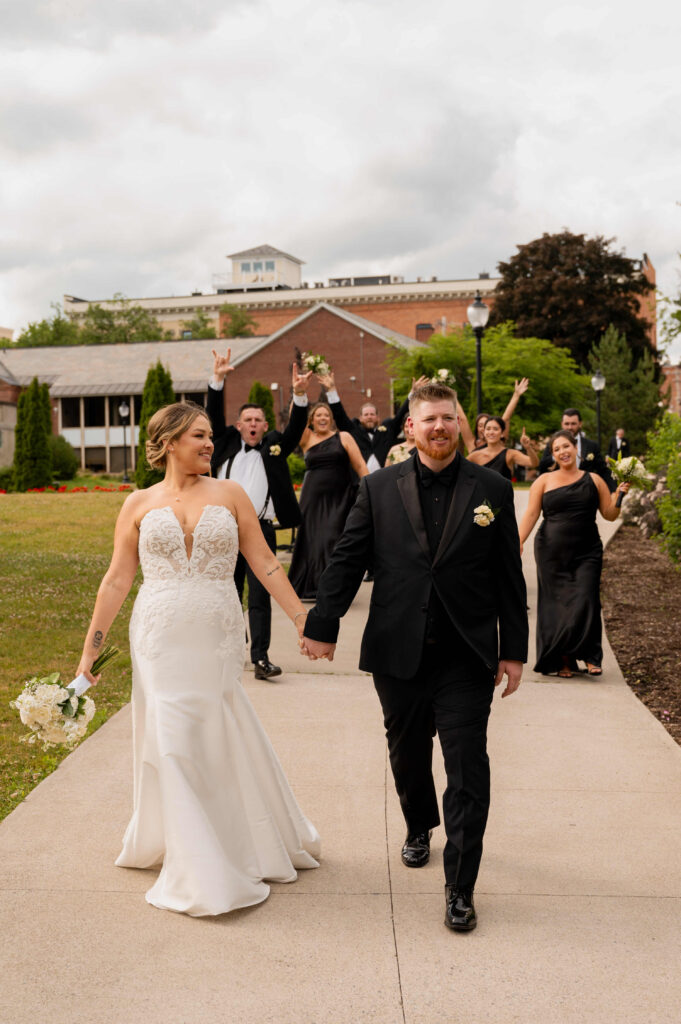 The bridal party celebrating the newly married couple on a walk through Congress Park in Saratoga Springs, New York.