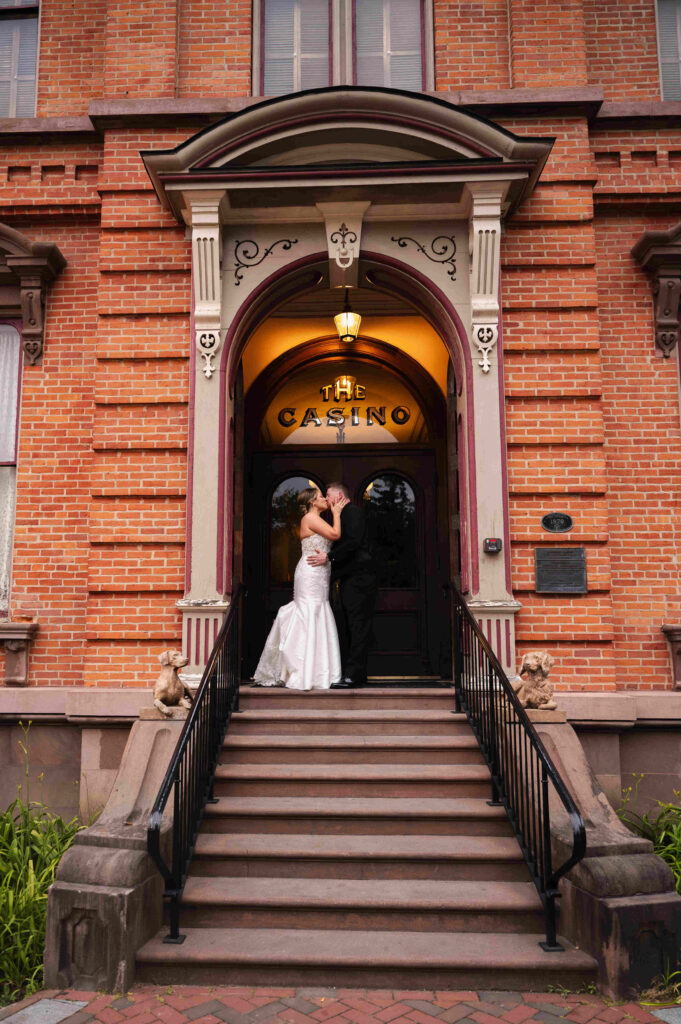 The bride and groom share a kiss on the stairs of the Canfield Casino in Saratoga Springs, New York.