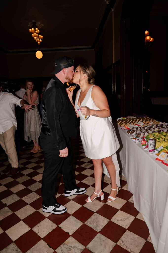 The bride and groom sharing a hamburger from McDonald's during their Canfield Casino wedding.