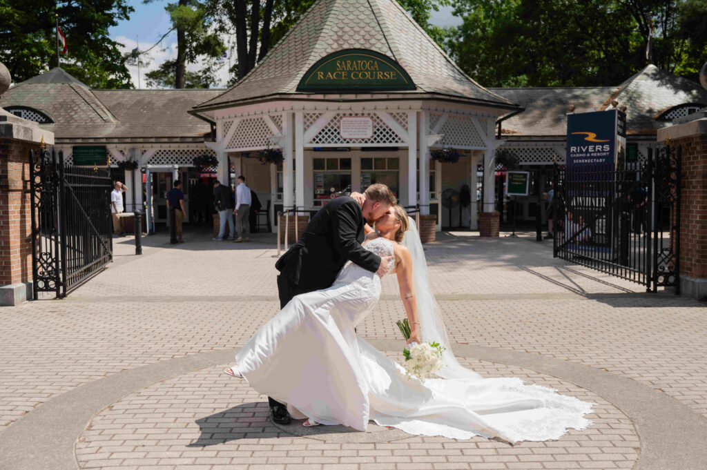 A photo of the bride and groom in front of the Saratoga Race Course from a wedding in Saratoga Springs, New York.