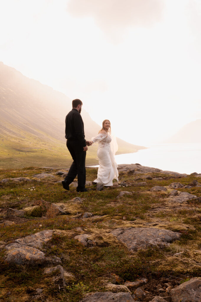 The bride and groom walking off into the sunset at Dynjandi Waterfall for their Iceland destination wedding photos.