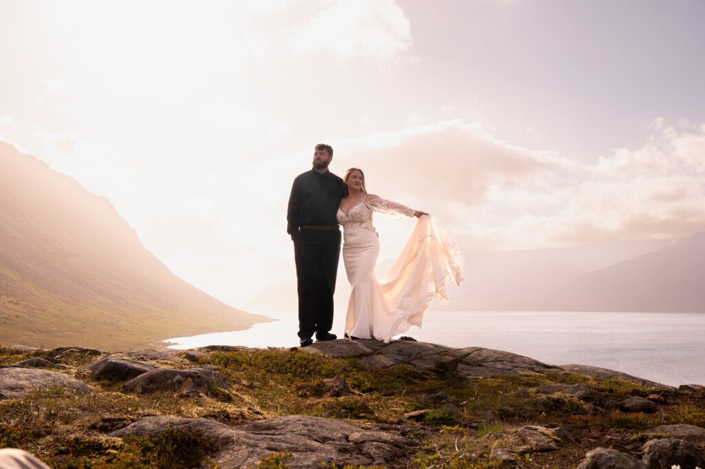 A portrait of a bride and groom during golden hour at Dynjandi Waterfall for their Iceland destination wedding.